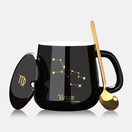 Black mug with Virgo zodiac design, gold spoon, and lid on a white background