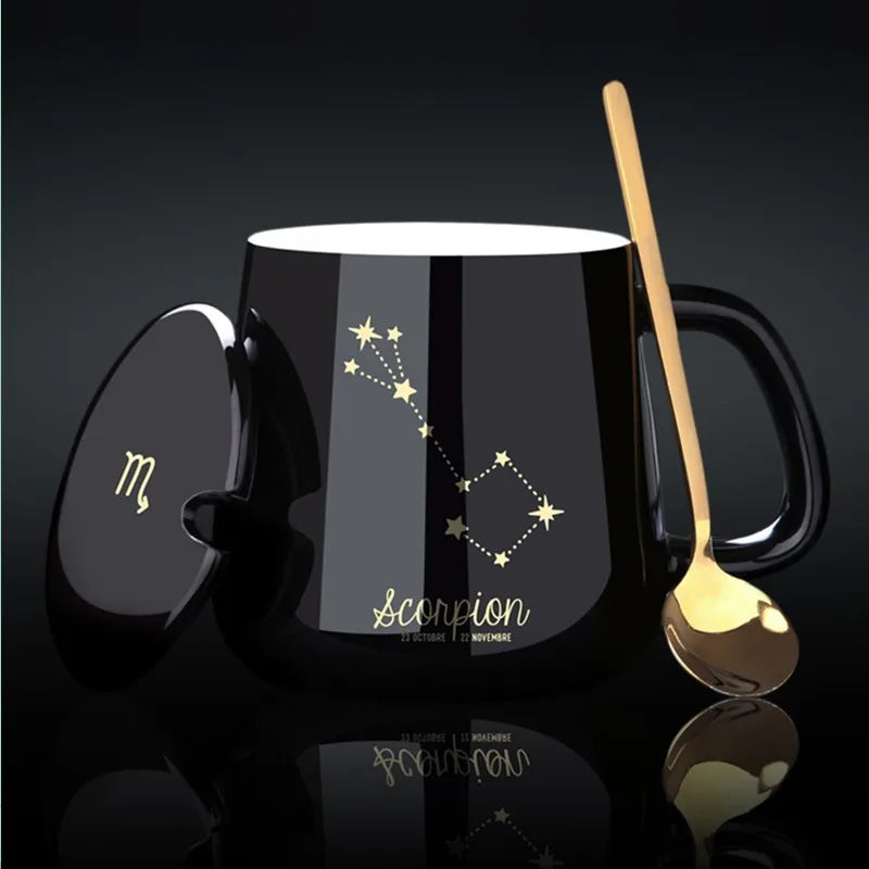 Black mug with Scorpion zodiac design, gold spoon, and lid on a dark background