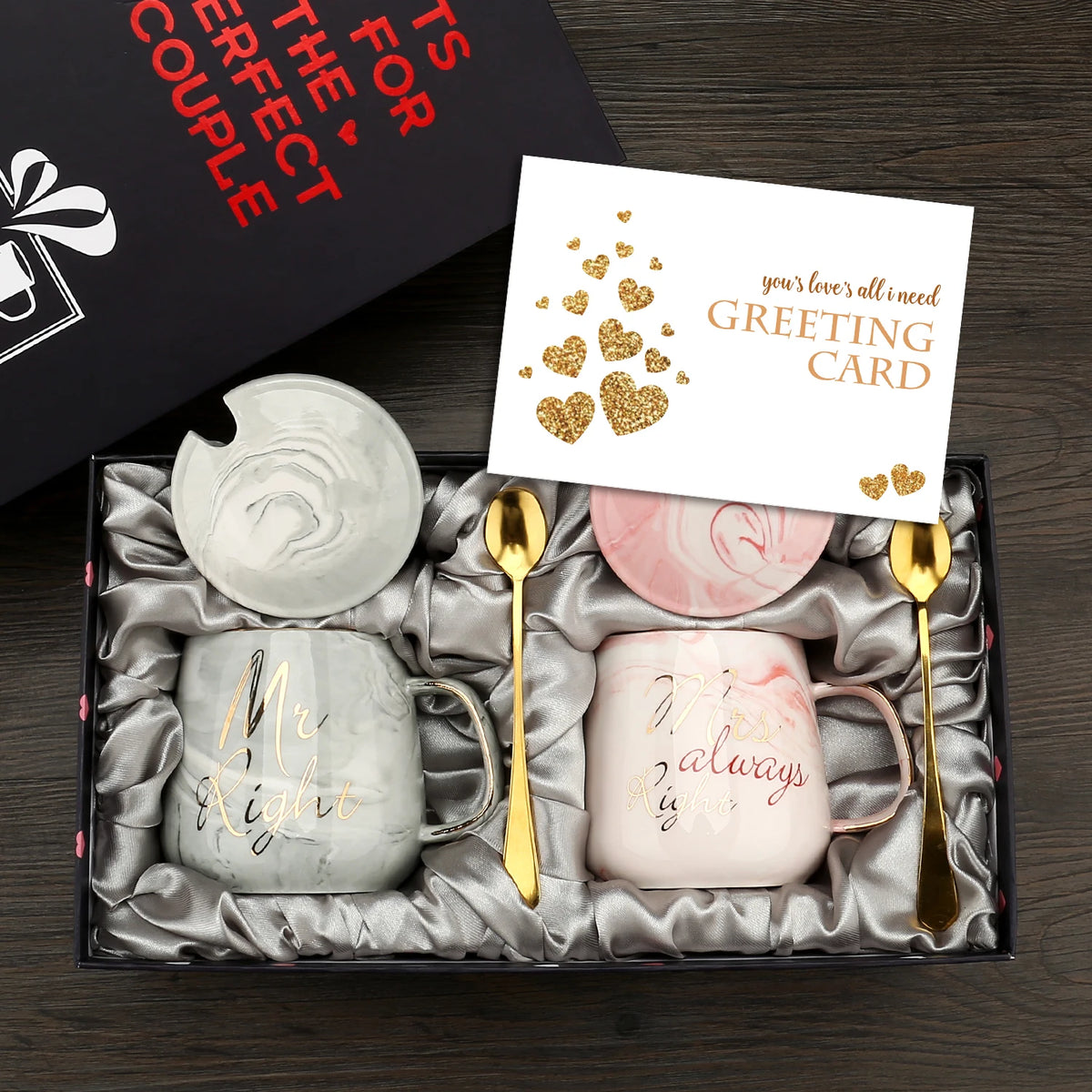Gift set with two mugs, coasters, and a card in a box on a wooden surface.