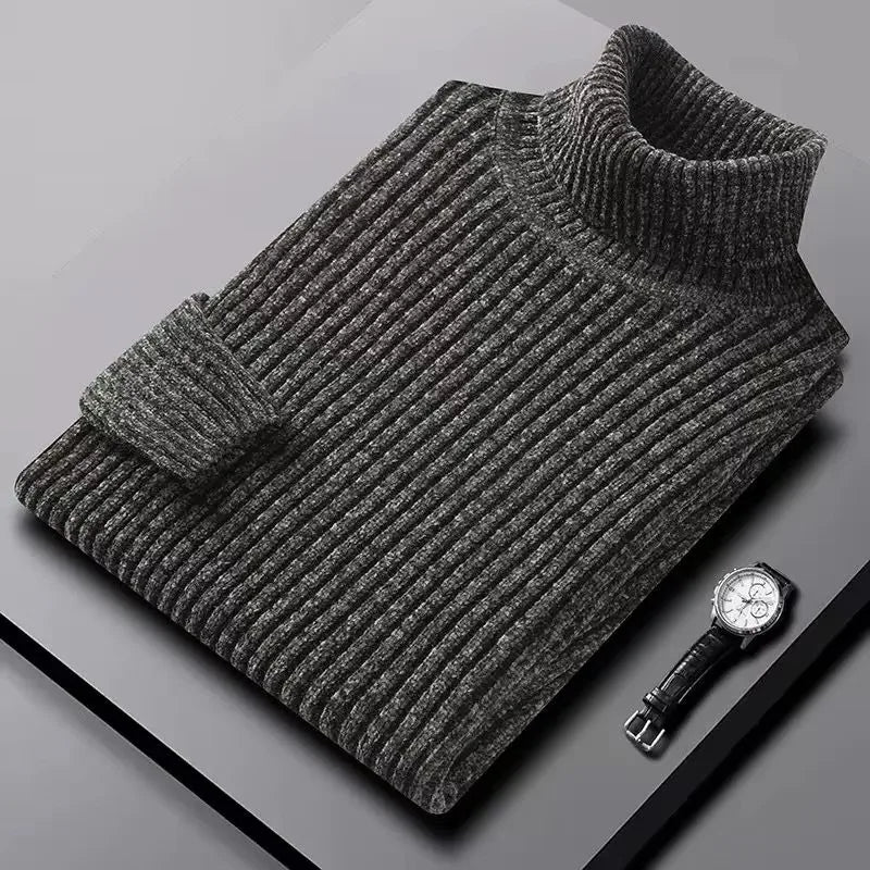Gray ribbed sweater on a gray surface with a watch beside it
