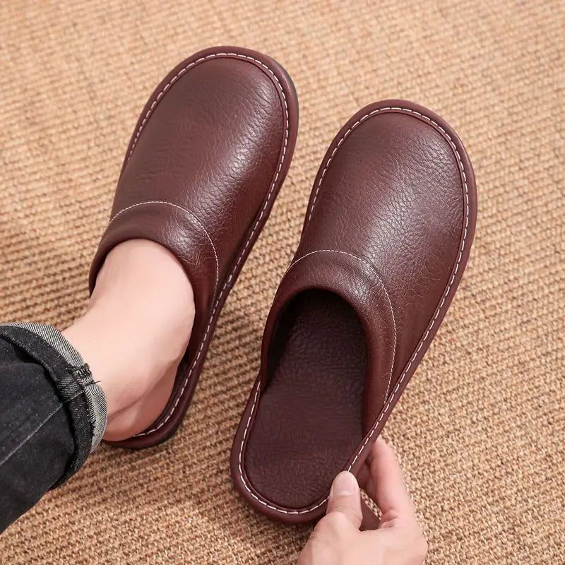 Brown leather slippers on a textured brown surface