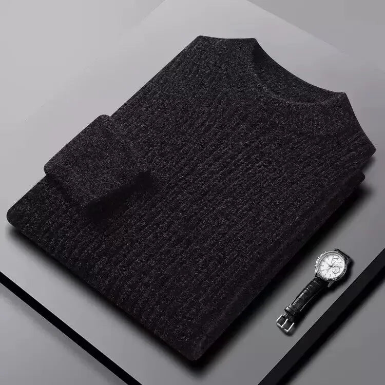 Dark gray sweater and watch on a light gray surface