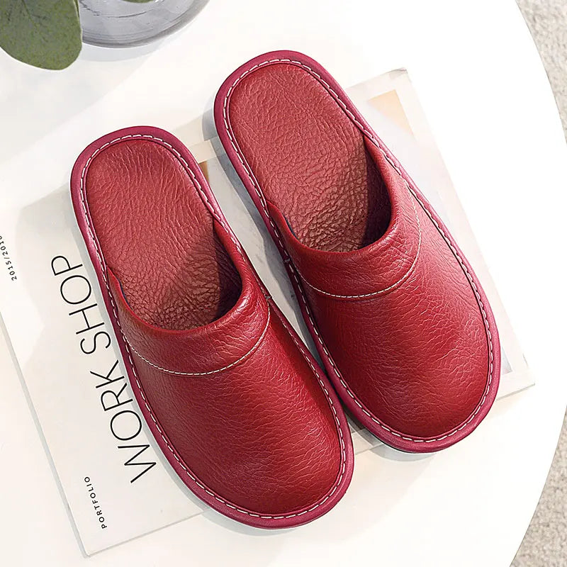 Red slippers on a white surface with a magazine underneath