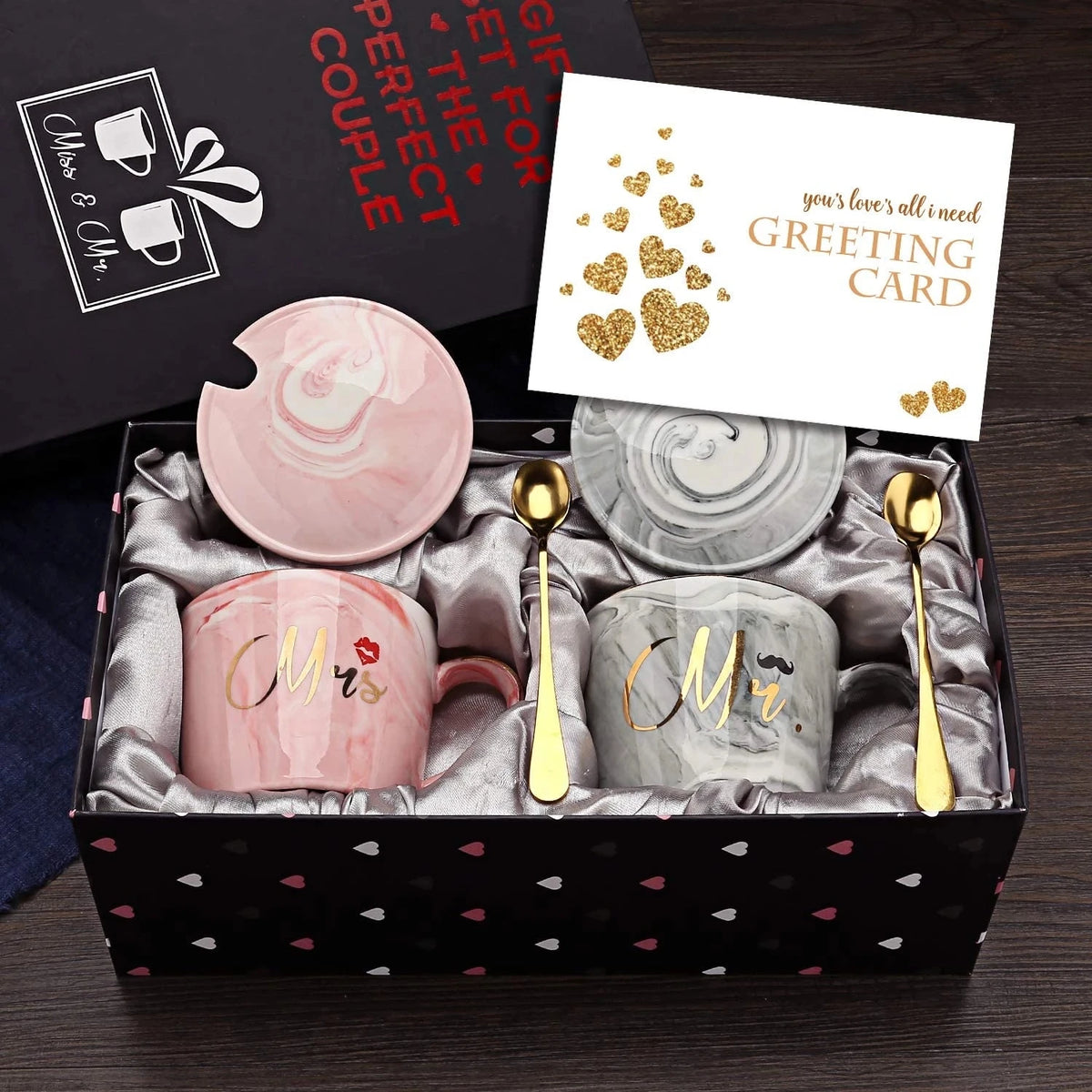 Gift set with 'Mr' and 'Mrs' mugs, spoons, and a card in a decorative box.