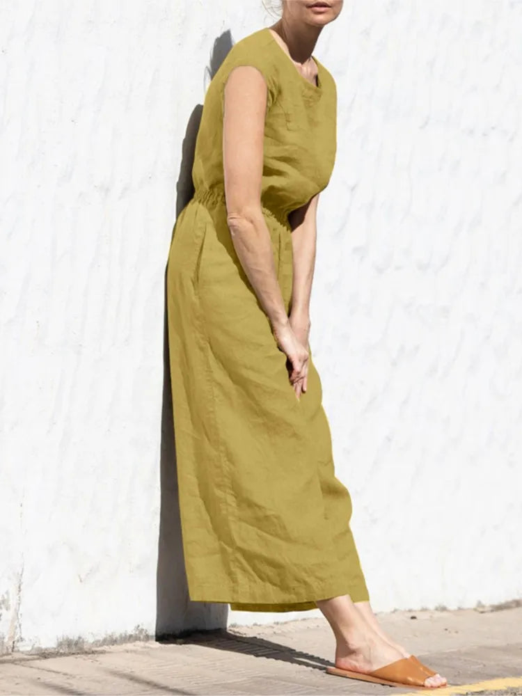 Person wearing a green dress against a white wall