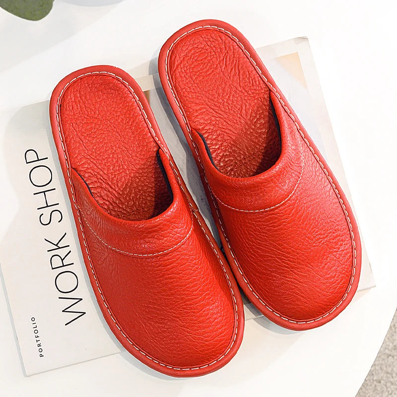 Pair of red slippers on a white surface with a book titled 'Workshop Portfolio' underneath.