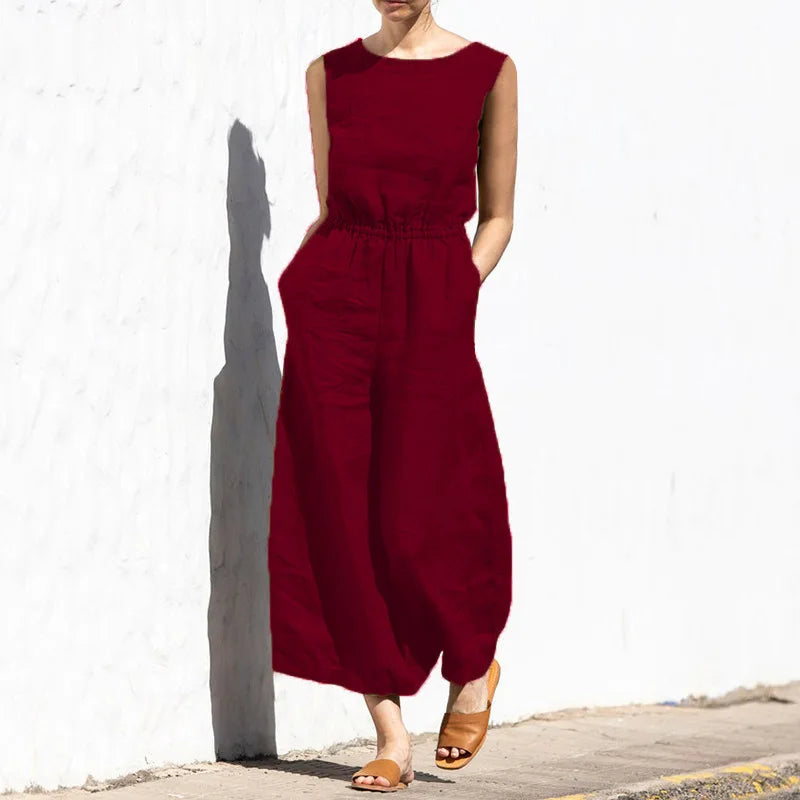 Person wearing a red jumpsuit standing against a white wall.