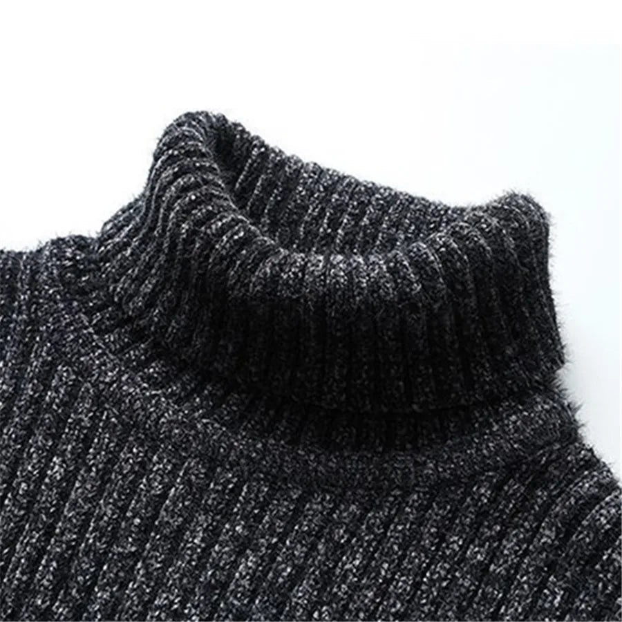 Close-up of a dark gray knitted sweater with a high collar on a white background
