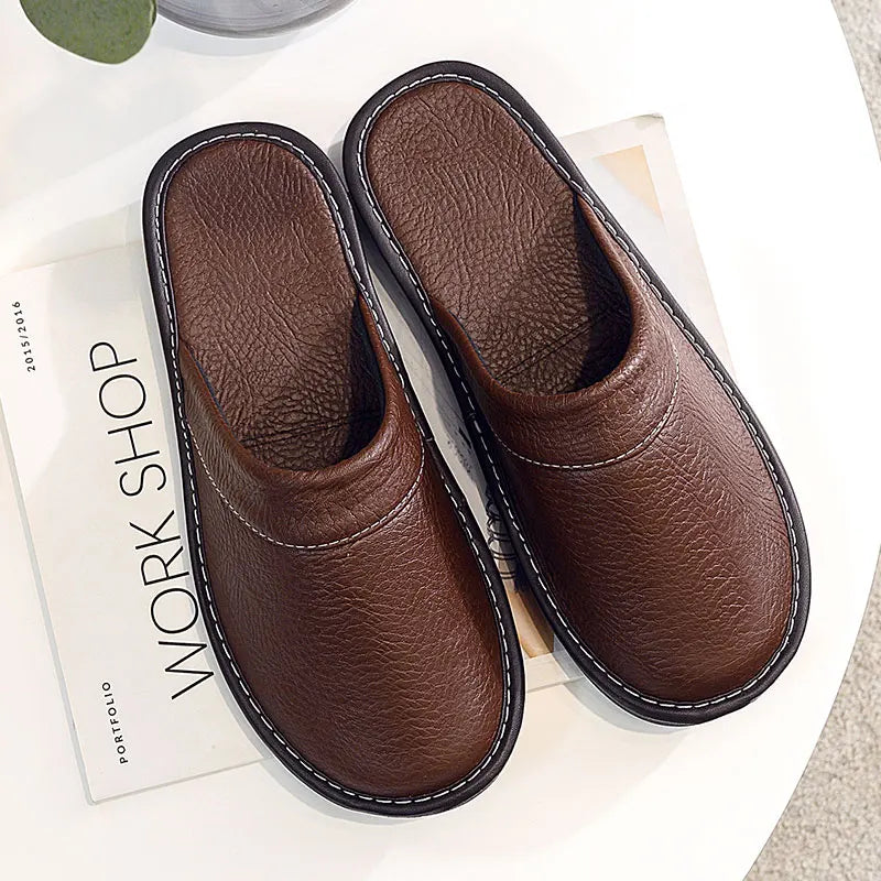 Pair of brown slippers on a surface with a magazine underneath.