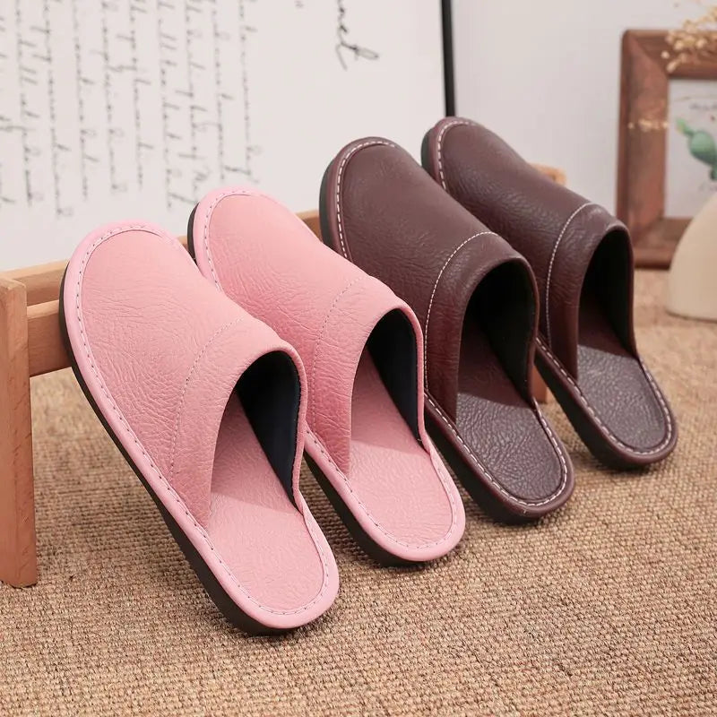 Pair of pink slippers and a pair of brown slippers on a textured surface.
