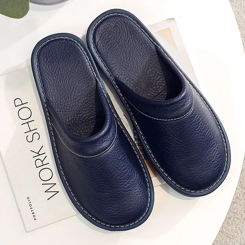 Pair of blue slippers on a white surface with a book underneath.