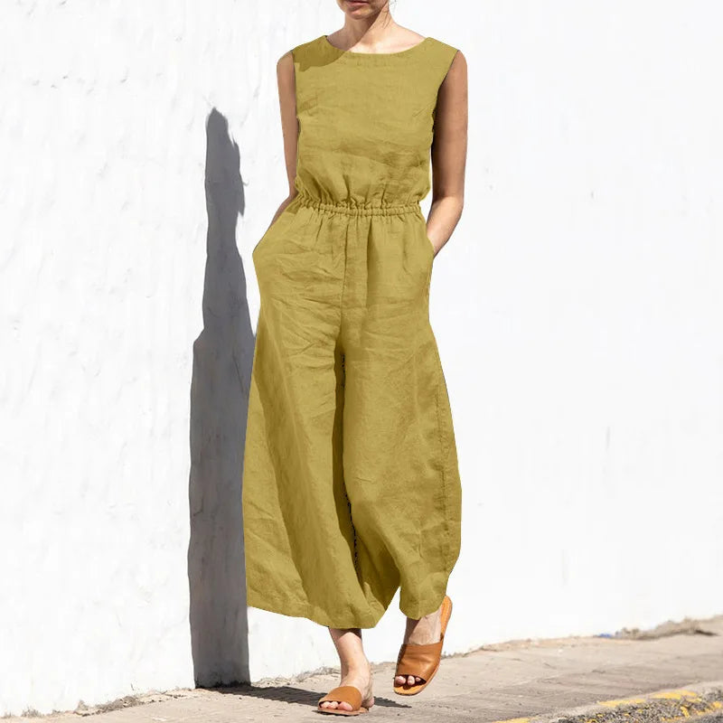 Person wearing a green jumpsuit standing against a white wall.
