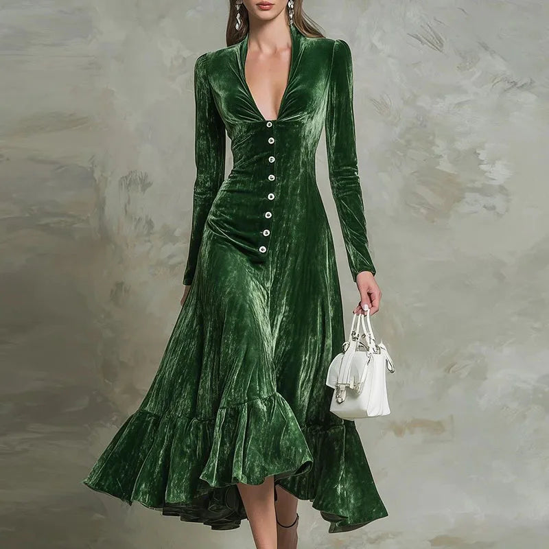 Green velvet dress with buttons and ruffled hem on a textured gray background