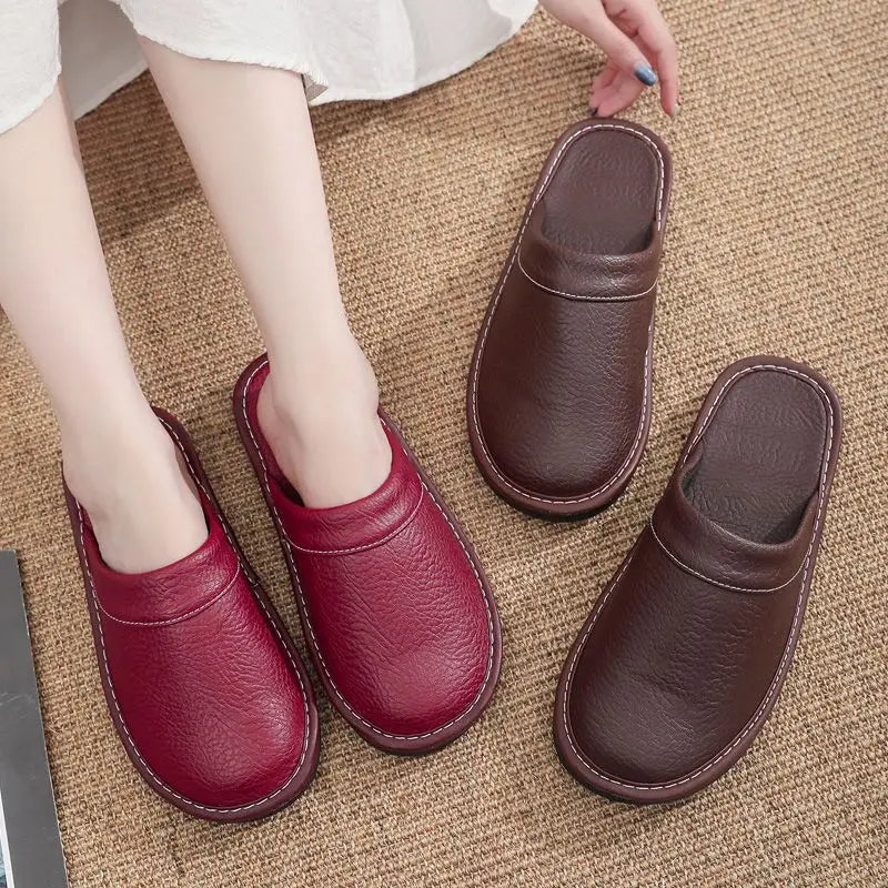 Red and brown leather slippers on a textured surface