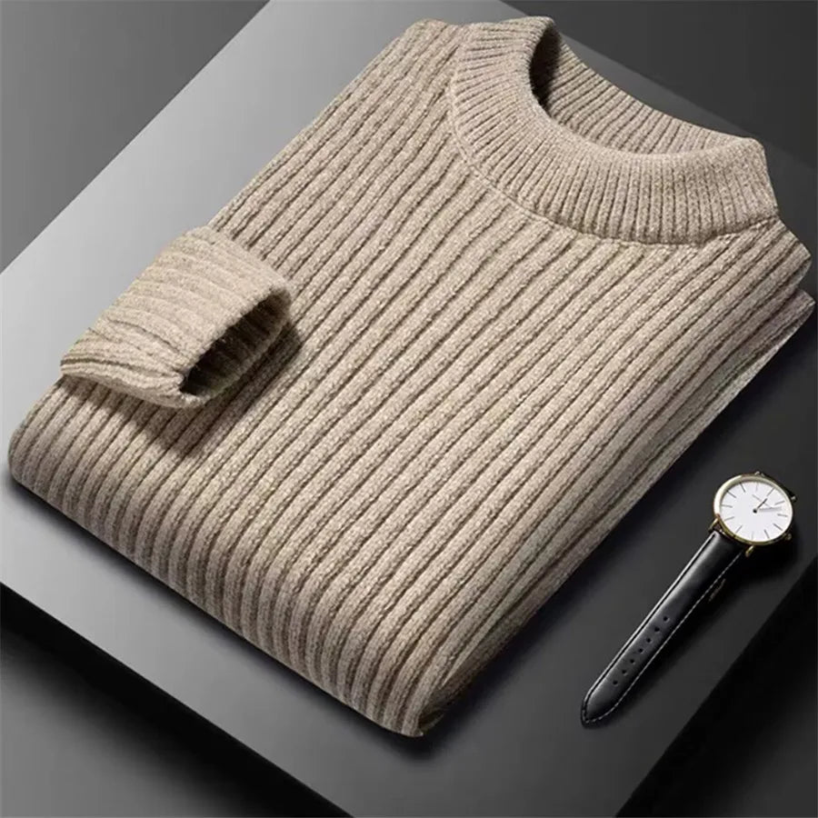 Beige ribbed sweater on a dark surface with a watch next to it
