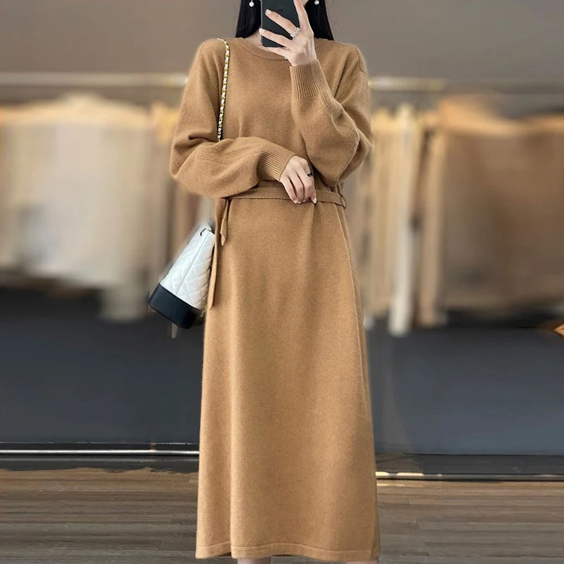 Person wearing a long brown dress with a blurred indoor background